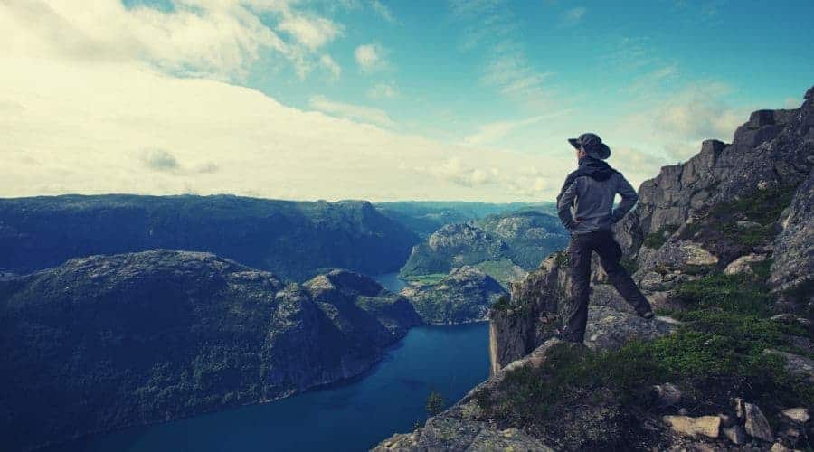 Man hiker looking over fjord panorama intext