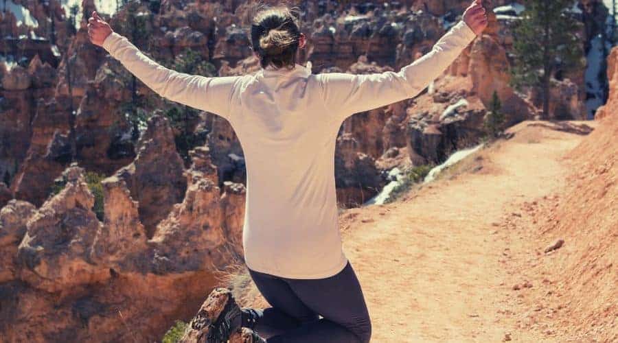 Silhouette of a Woman Jumping Over Dirt Trail in Hiking Leggings