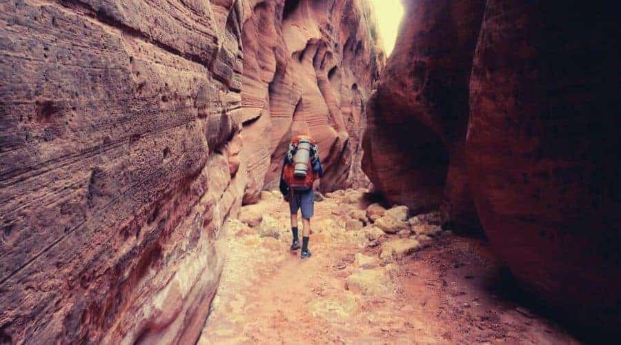 hiking through a narrow slot canyon