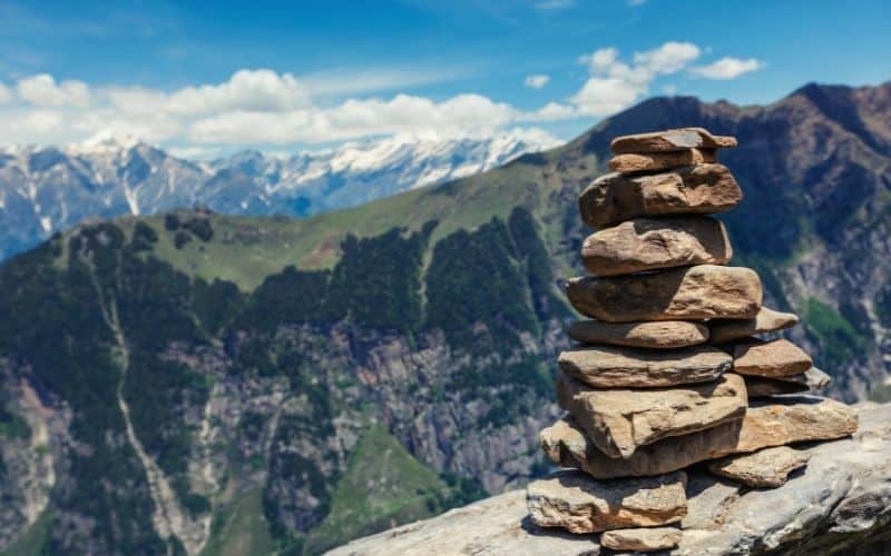 Rock cairn on a clifftop overlooking Himalayas