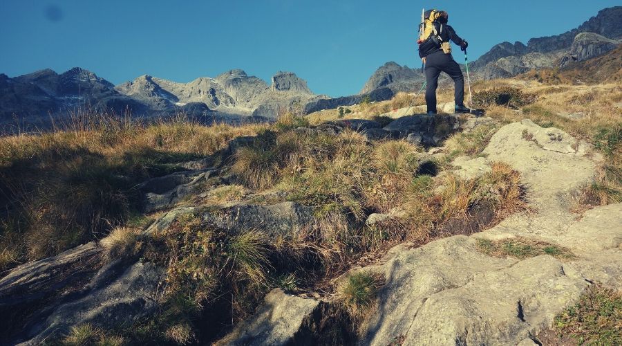 hiker walking towards cairn intext