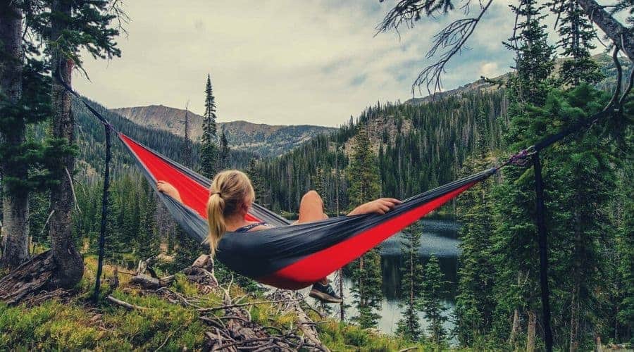 female hiker in hammock overlooking river valley intext