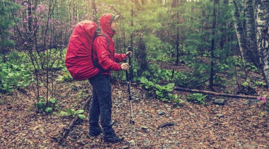 hiker in the fog with the red backpack in rainy weather intext