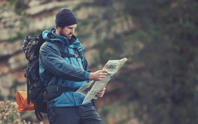 Hiker reading a map wearing hiking gear