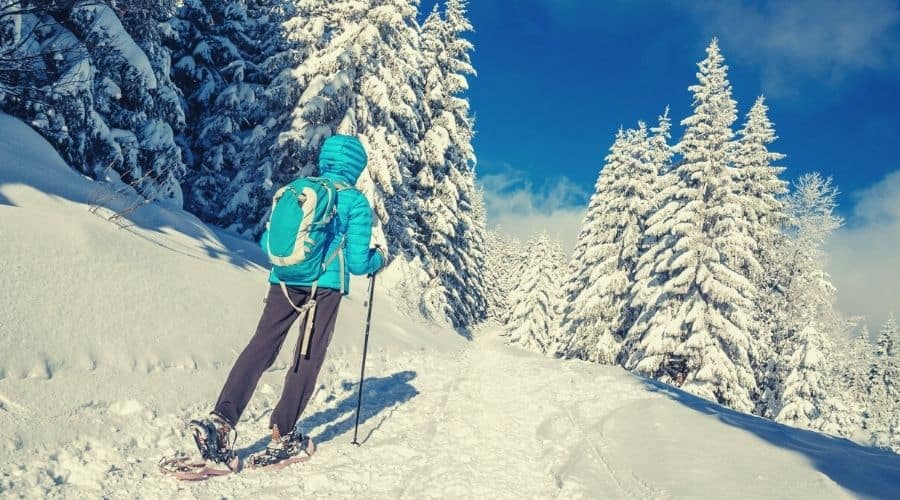 woman snow shoeing in down jacket