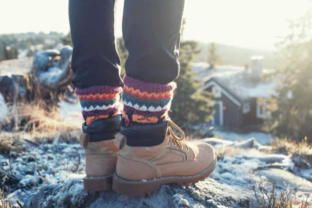 Hiker wearing hiking boots and winter socks in the snow