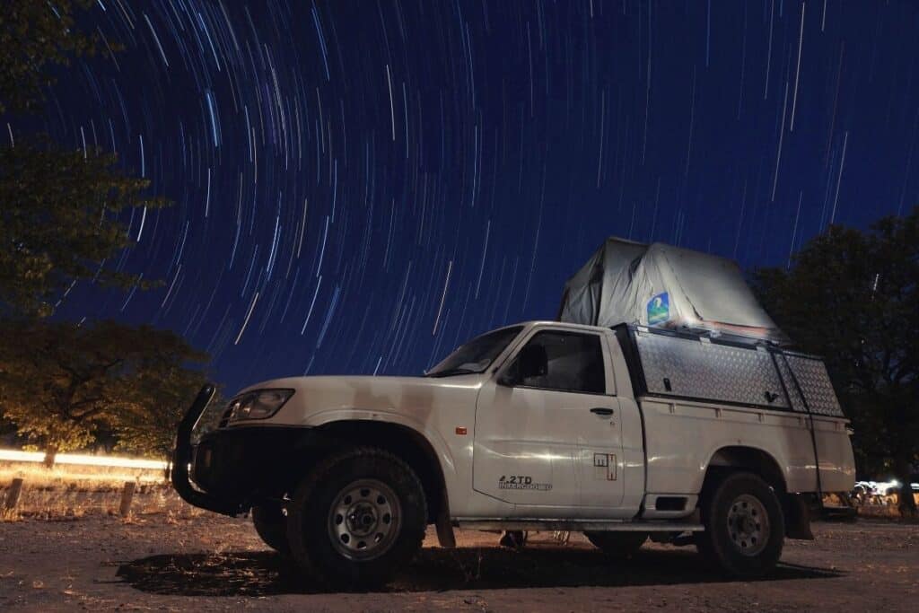 Truck with a roof tent under a starry night sky