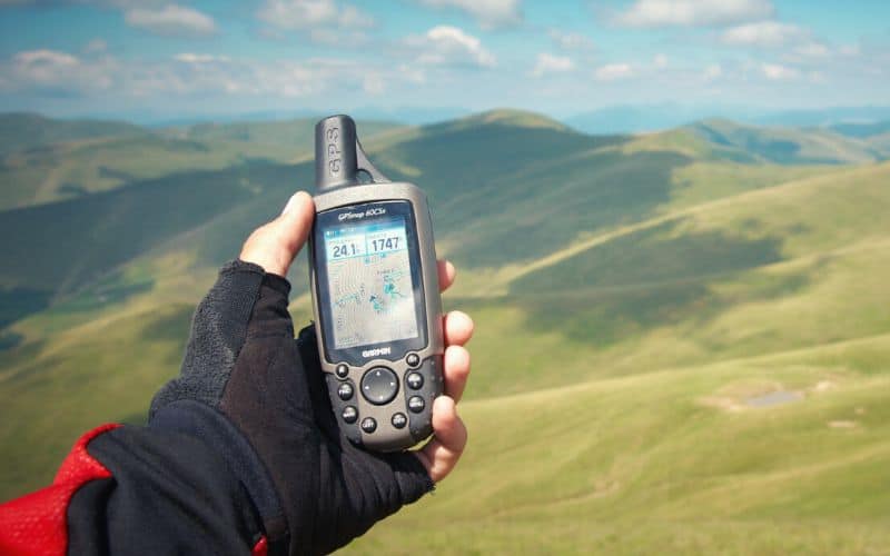 GPS device with soft keys in front of hilly landscape