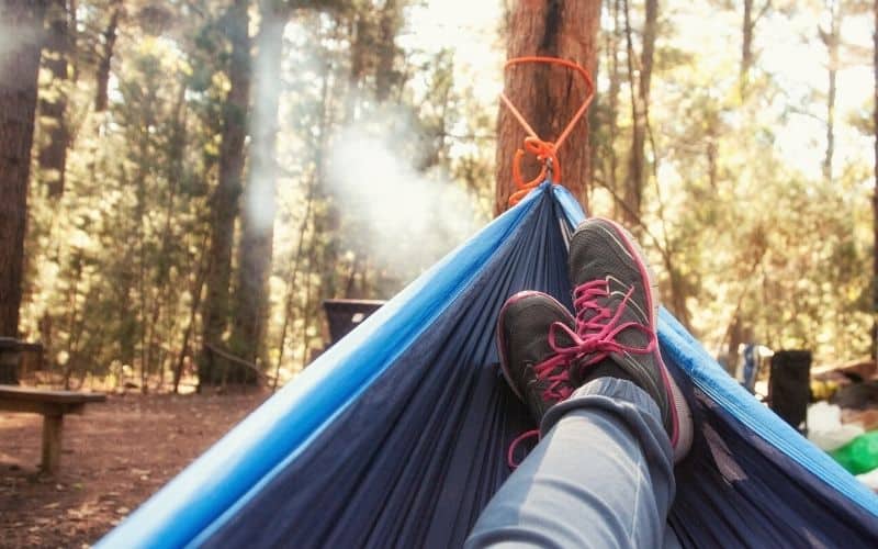 Hammock suspended by rope tied to tree 