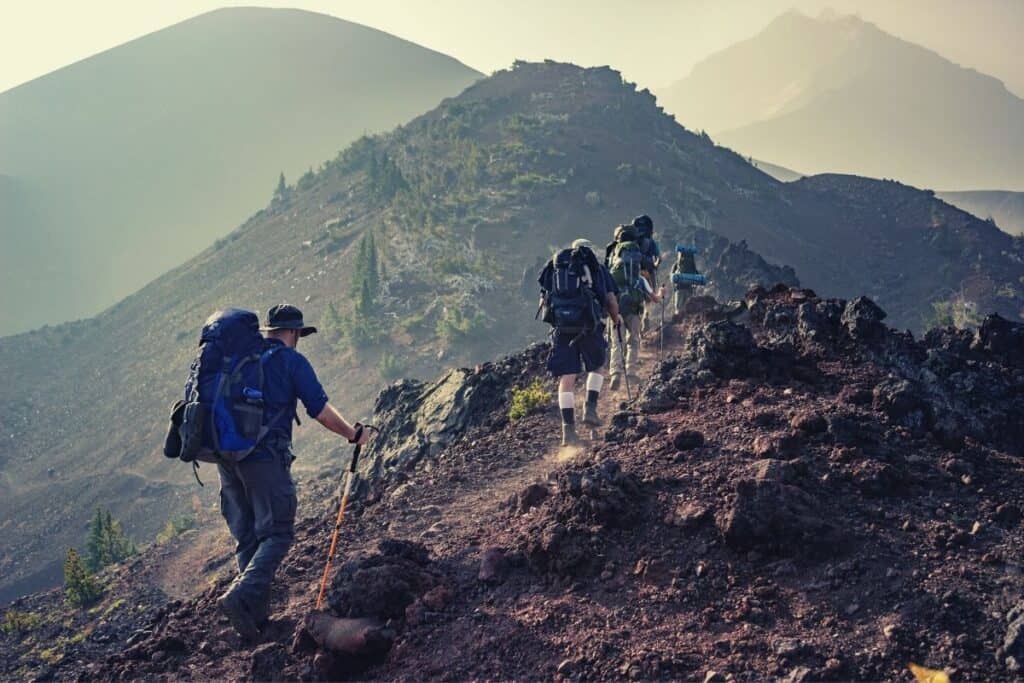 Hikers walking over undulating ground in the mountains
