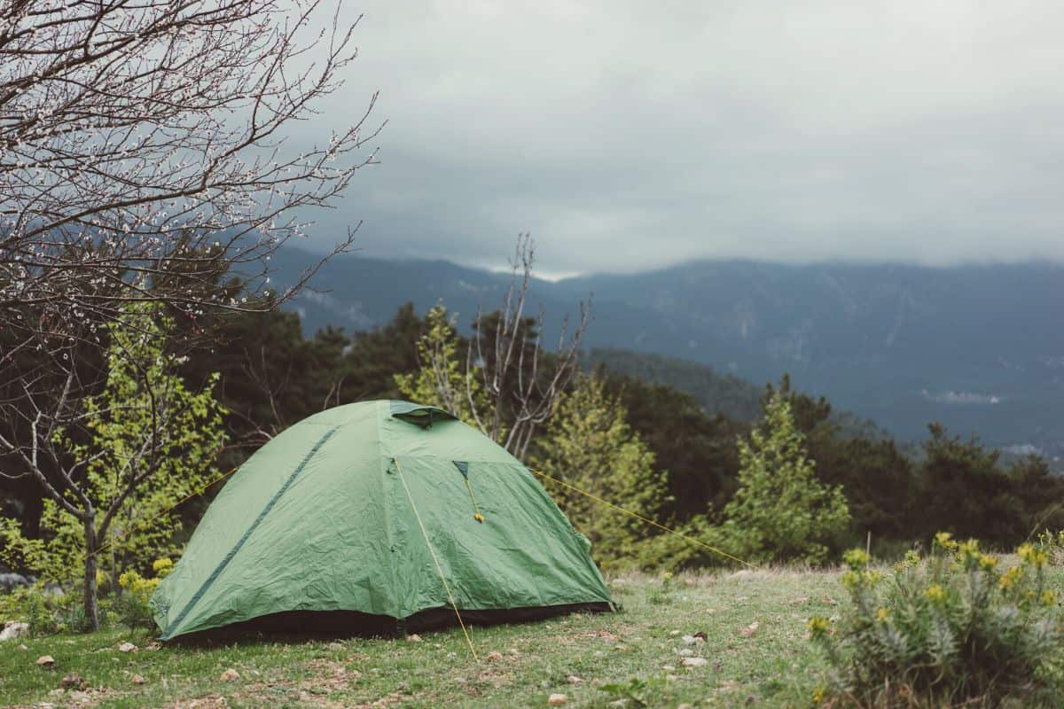 Tent pitched on mountainside with grey skies