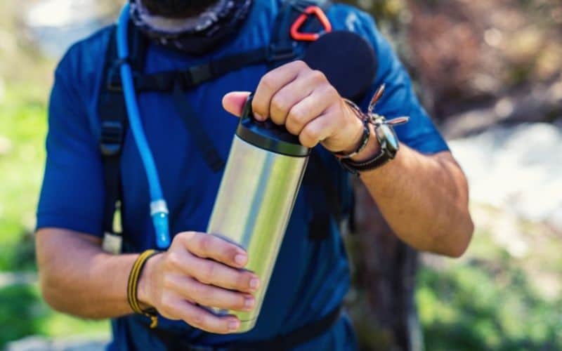 hiker carrying stainless steel flask