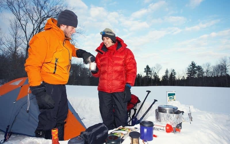 two campers camping in snow