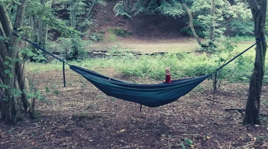woman chilling in a hammock in the woods