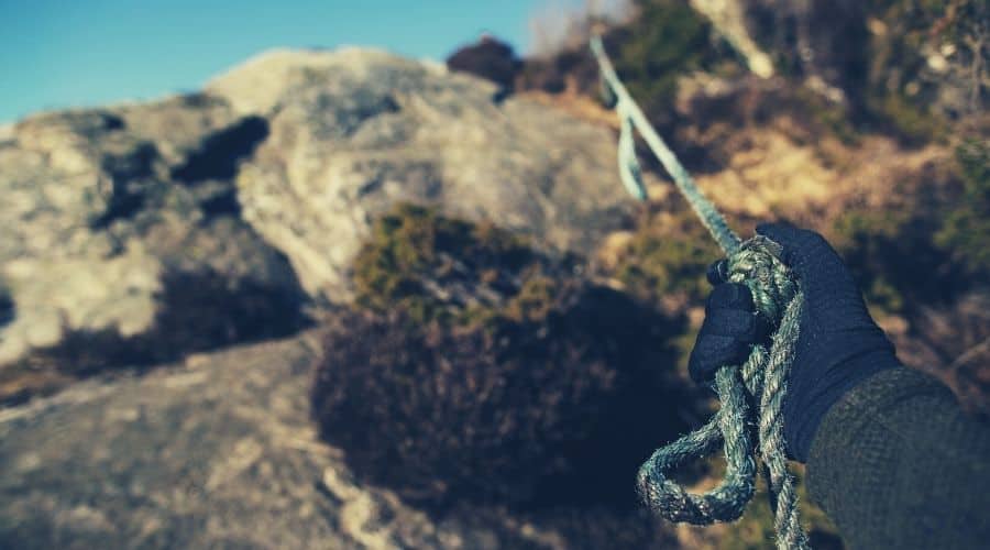 hiker wearing gloves pulling on rope