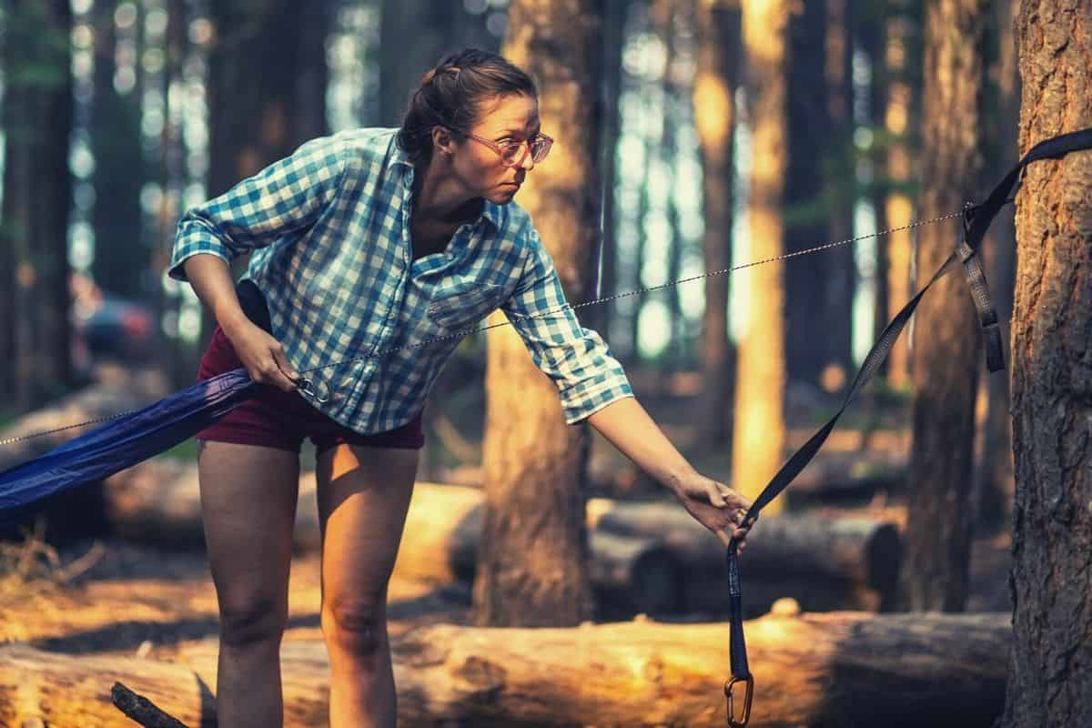 Woman hanging a hammock - how to hang a hammock featimg