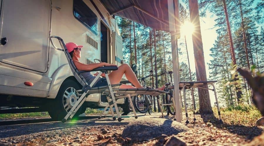 woman camper relaxing in RV shade on hot sunny day