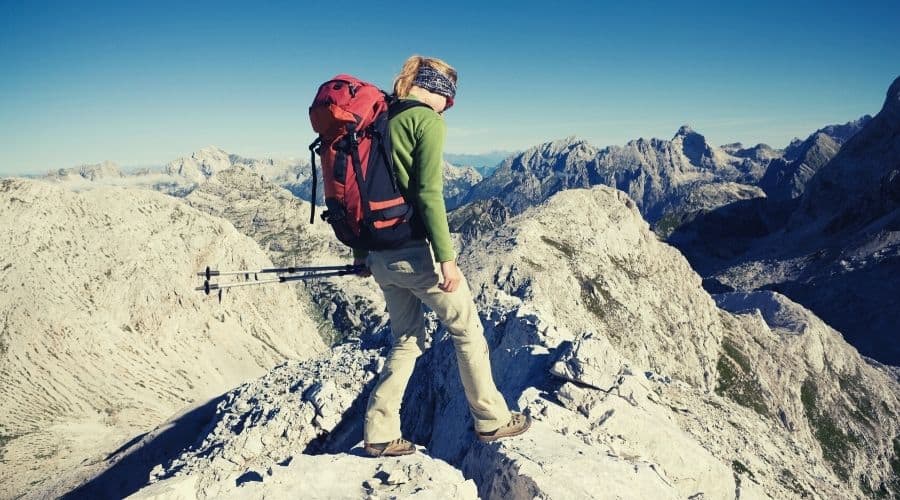 woman walking over rocky outcrop in mountains