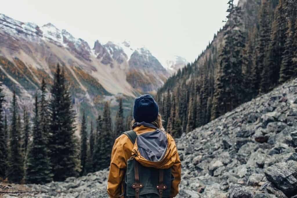 Hiker wearing beanie standing in front of mountains