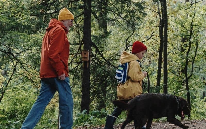 Man and child hiking through forest wearing beanies