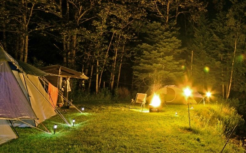 Campsite at night lit up with various lighting