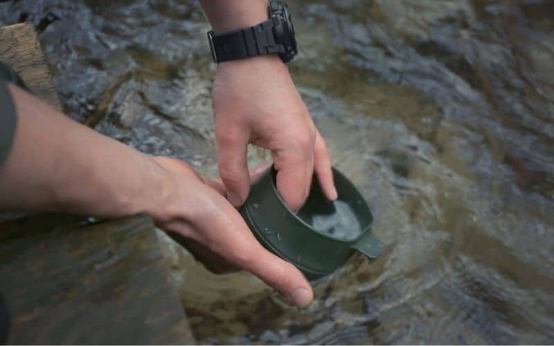 Cleaning a cup directly in a river