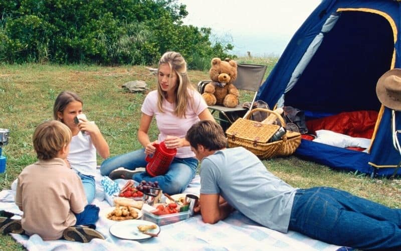 Family having a picnic in front of their tent
