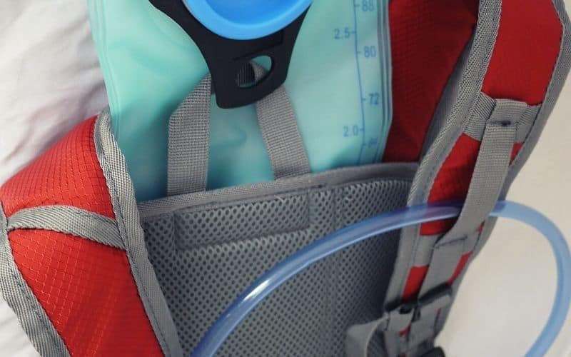 Hydration bladder sticking out of hydration compartment in backpack
