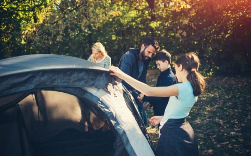Kids and parents pitching a tent
