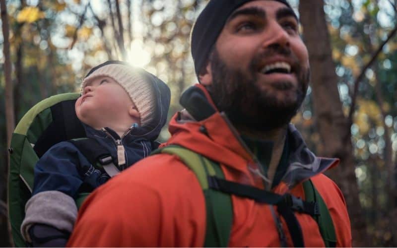 Man carrying baby on his back in a baby carrier