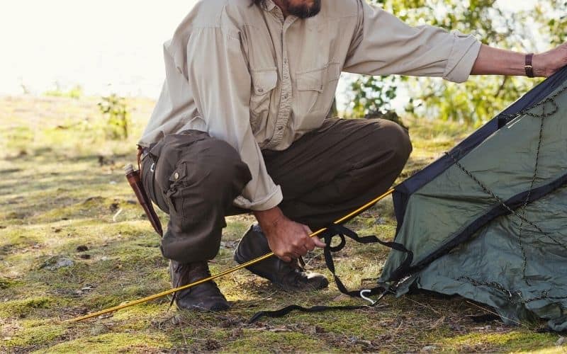 Man setting up tent with color coded tent poles