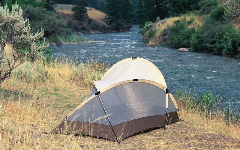 Tent pitched beside a river
