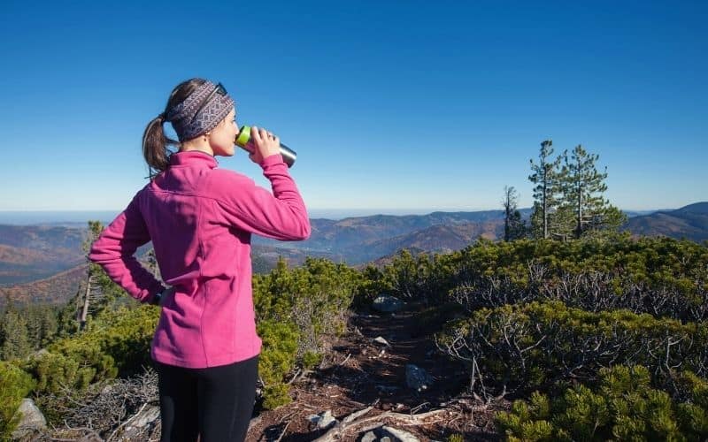 female hiker drinking water