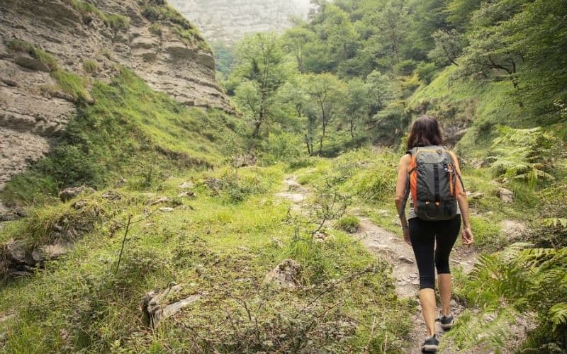 female hiker in leggings walking thru canyon