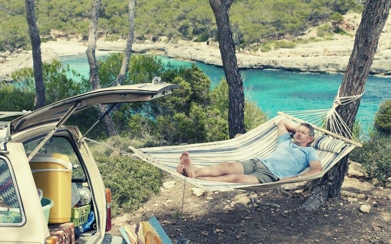 man hanging hammock off car tail gate