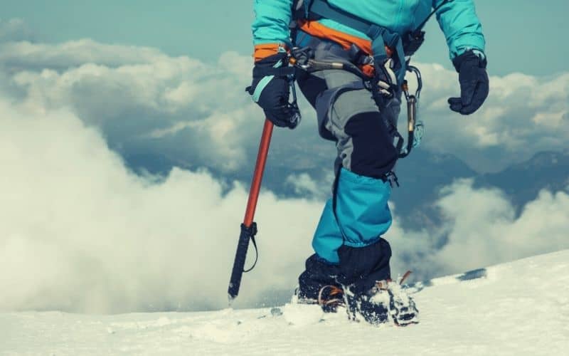 mountaineer with mountaineering pants, gaiters and crampons