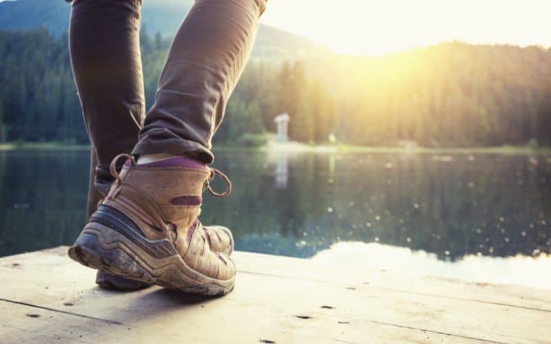 Hiker in hiking boots standing in front of a lake