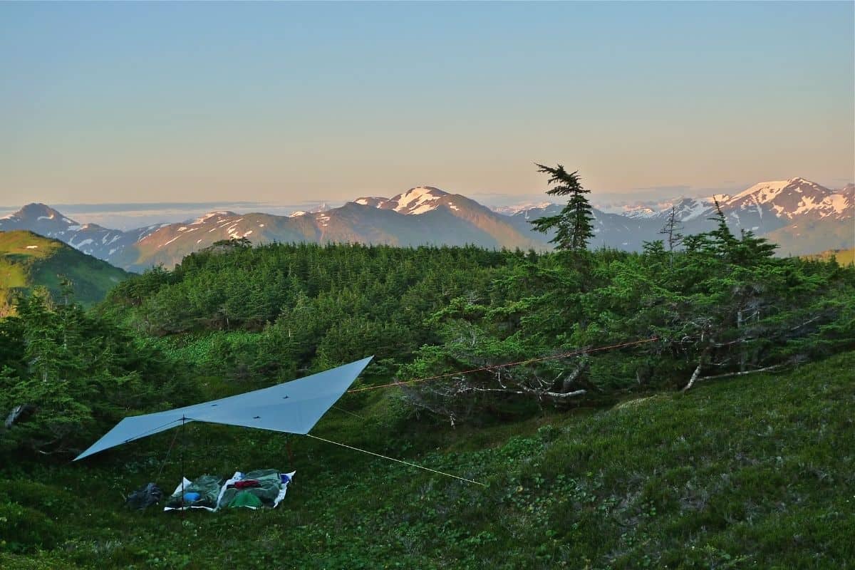 People camping under a tarp in Alaska