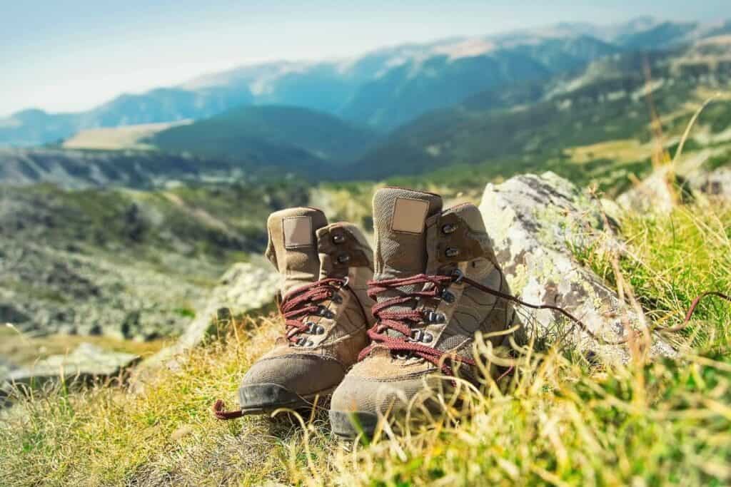 Hiking boots sitting on grass on a mountain