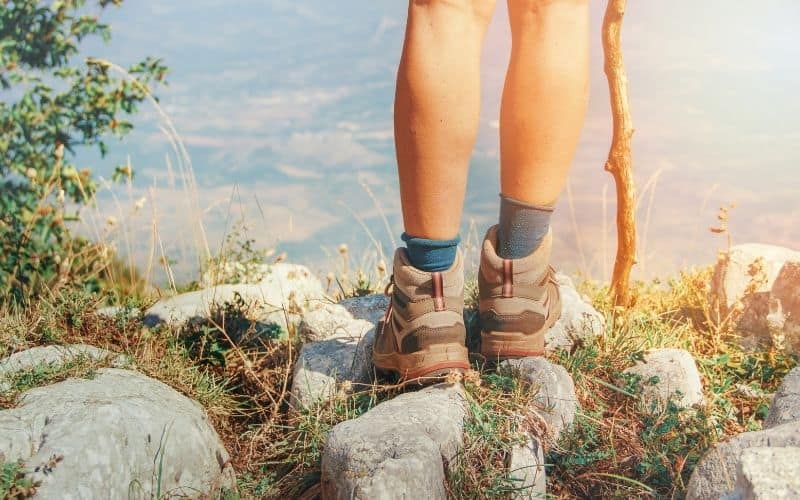 hiker standing on mountain top wearing hiking boots