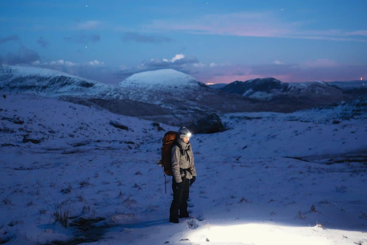 Hiker in snow with headlamp on