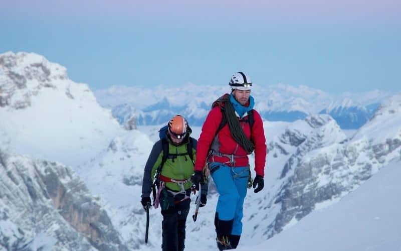 Hikers wearing headlamp climbing mountains in the snow