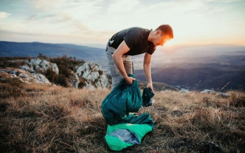 Backpacker packing away sleeping bag