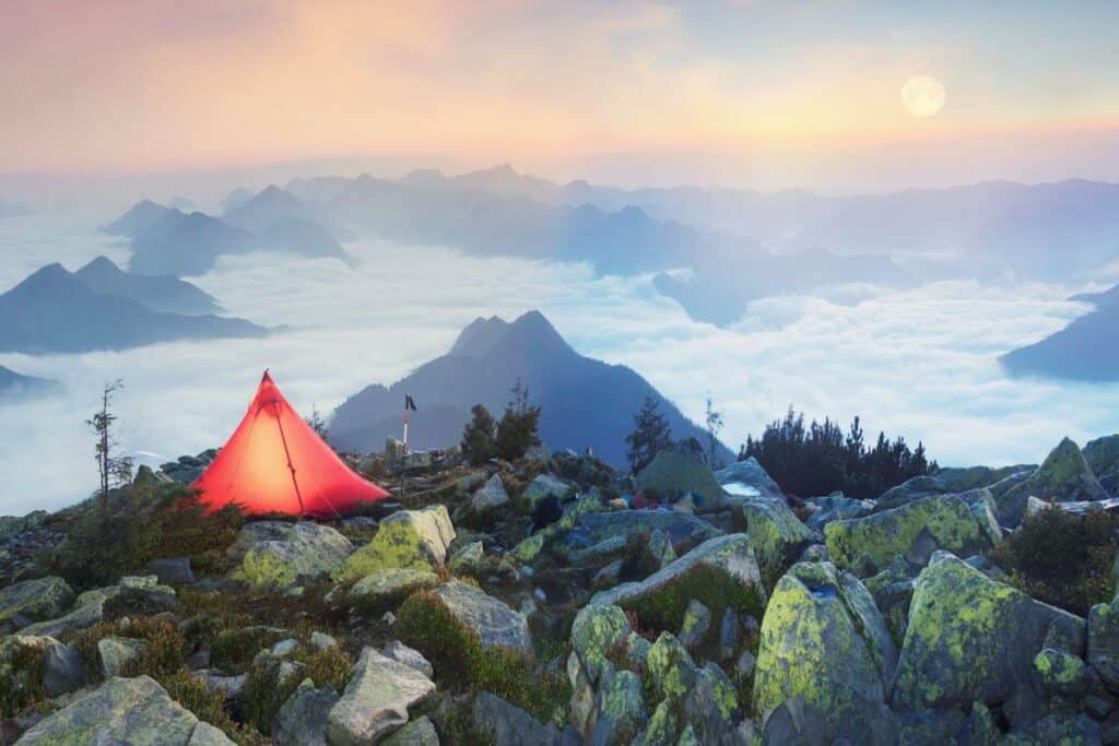 Lit up tent on top of mountain