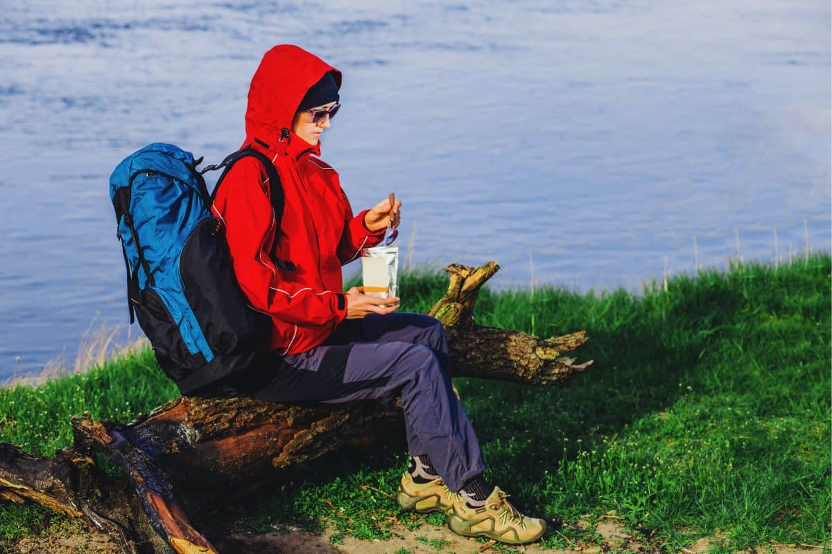 Woman eating a freeze dried meal out of a foil packet