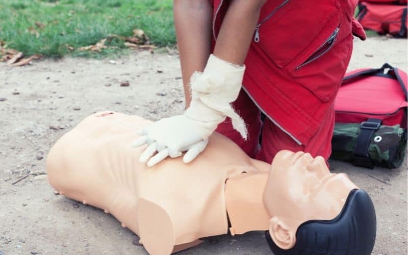 Person practicing heart compressions on a dummy