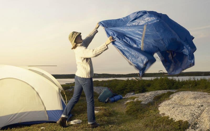 Woman laying out tent tarp footprint