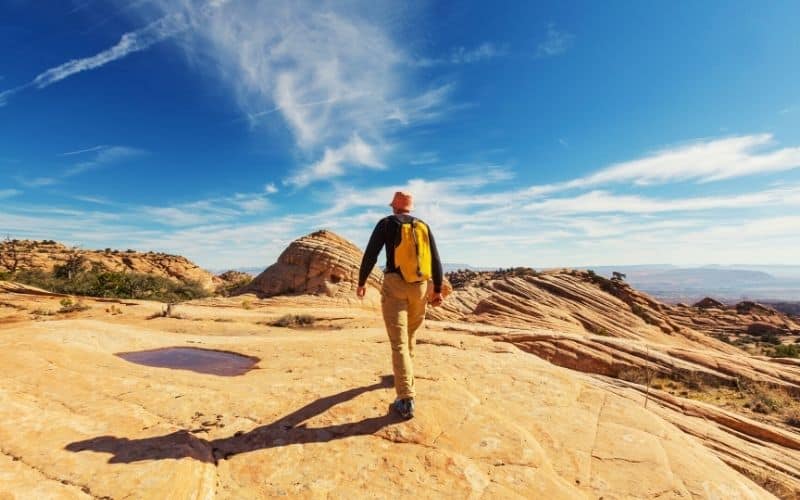hiker-hiking-across-rocky-desert-with-bucket-hat