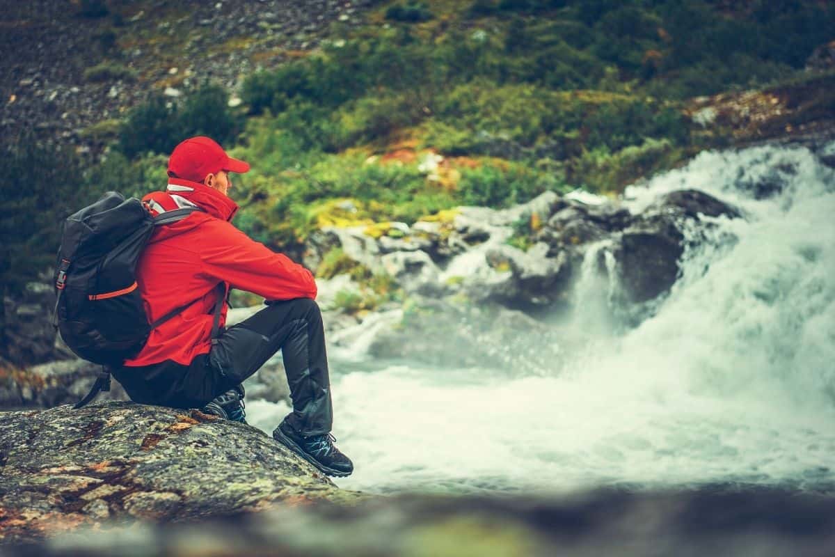 Man sitting next t o a waterfall