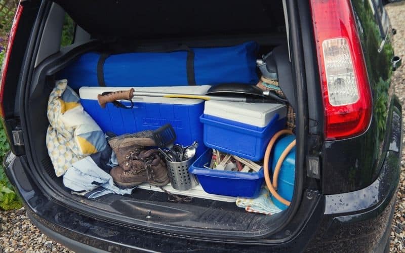 Car boot filled with coolers and hiking equipment